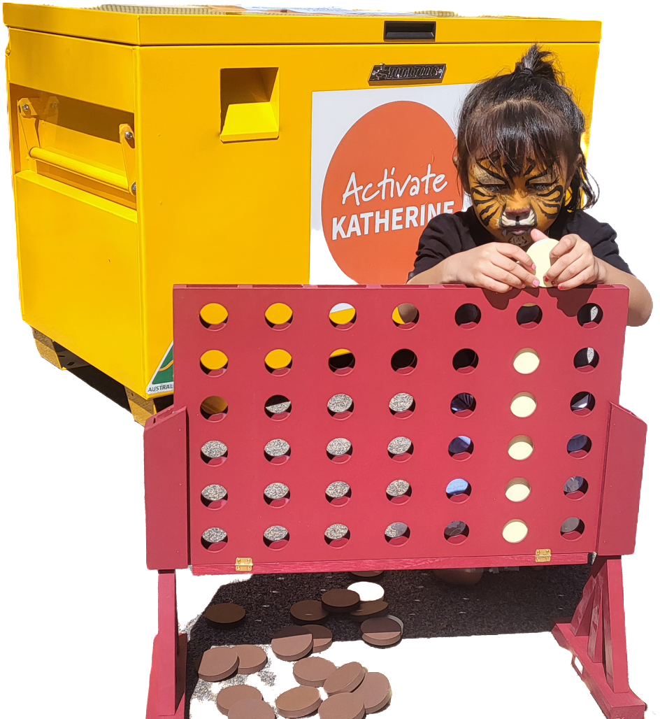A kid is playing 4 in rows in front of a fun box 
